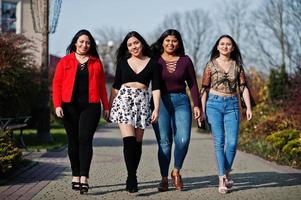 Group of four happy and pretty latino girls from Ecuador posed at street. photo