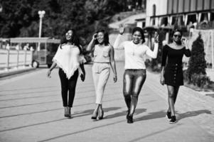 Group of four african american girls walking at city on sunny day. photo