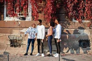 cuatro amigos africanos caminando por las calles de una ciudad antigua. foto