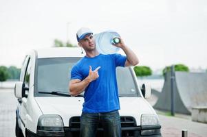 repartidor en camioneta de carga delantera entregando botellas de agua mostrando el dedo. foto