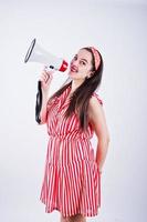 Portrait of a young beautiful woman in red dress talking into megaphone. photo