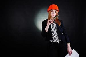 mujer ingeniera en casco de protección naranja con proyecto de papel de construcción. foto