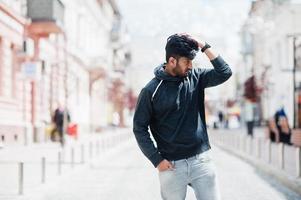 Portrait of young stylish indian man model pose in street. photo