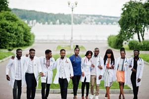 Group of african medical students posed outdoor in white lab coats. photo