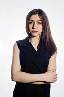 Close-up emotional portrait of a brunette girl in black jumpsuit on white background. photo