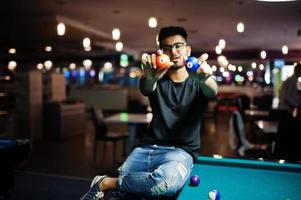 Stylish asian man hold pool billiard balls. photo