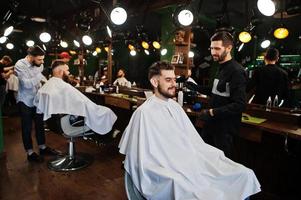 Handsome bearded man at the barbershop, barber at work. photo