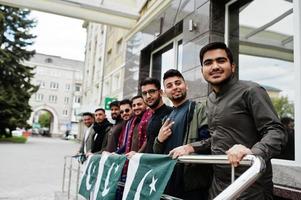 grupo de hombres paquistaníes vestidos con ropa tradicional salwar kameez o kurta con banderas de pakistán. foto