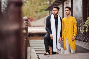dos amigos indios con estilo en ropa tradicional posan al aire libre. foto