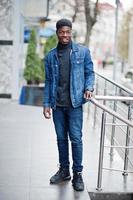 desgaste de hombre africano en chaqueta de jeans posada al aire libre. foto