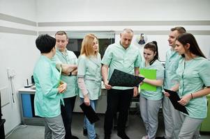 tema médico.sala de observación con un tomógrafo computarizado. el grupo de médicos reunidos en la oficina de resonancia magnética y mirando rayos X en el centro de diagnóstico del hospital. foto