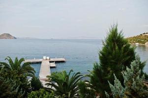 muelle de madera. paisaje escénico con islas de montaña y laguna azul en el mar Egeo. paisaje exótico. punto de referencia popular, famoso destino de bodrum, turquía. foto