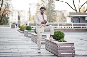 hombre afro con estilo en traje beige de la vieja escuela. joven africano de moda con chaqueta informal en el torso desnudo. foto