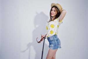 Girl tourist with bag, wear in shirt, shorts and hat with glasses isolated on white. photo