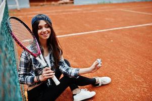 Young sporty girl player with tennis racket on tennis court. photo