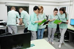 Medical theme.Observation room with a computer tomograph. The group of female doctors with clipboards meeting in the mri office at diagnostic center in hospital. photo