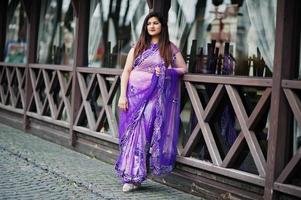 Indian hindu girl at traditional violet saree posed at street. photo