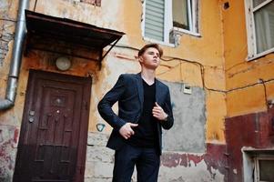 Young stylish macho boy in black jacket posed outdoor of street. Amazing model man. photo