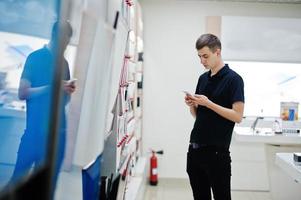 vendedor hombre consultor profesional de telefonía móvil en tienda o tienda de tecnología. foto