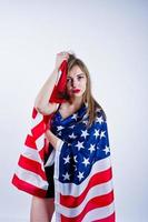 linda chica en sujetador y pantalones cortos con bandera americana de estados unidos aislada sobre fondo blanco. foto