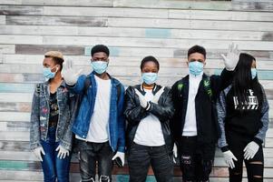 grupo de amigos adolescentes africanos que usan máscaras médicas protegen de infecciones y enfermedades cuarentena del virus del coronavirus. foto