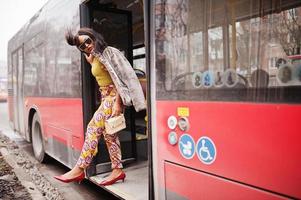 Young stylish african american woman in modern sunglasses riding on a bus. photo