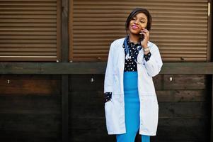 African american doctor female with stethoscope speaking at phone. photo