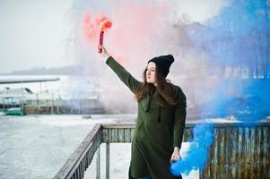 Young girl with blue and red colored smoke bomb in hands. photo