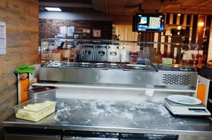 Female chef preparing pizza in restaurant kitchen. photo