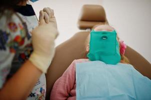 Little baby girl at dentist chair. Children dental. photo