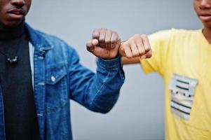 Fist to fist. Two african male friends shaking hands. photo
