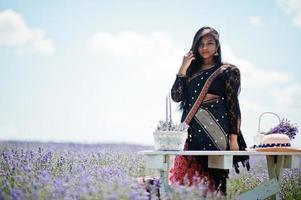 Beautiful indian girl wear saree india traditional dress in purple lavender field. photo