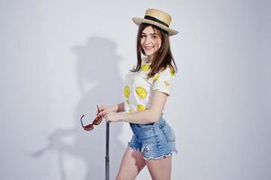 Girl tourist with bag, wear in shirt, shorts and hat with glasses isolated on white. photo