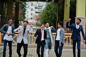 Group of six south asian indian mans in traditional, casual and business wear walking dancing and having fun together. photo