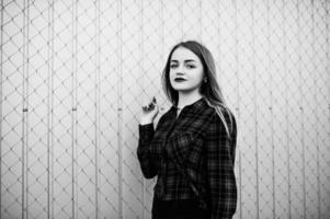 Young hipster girl in checkered shirt posed outdoor. photo