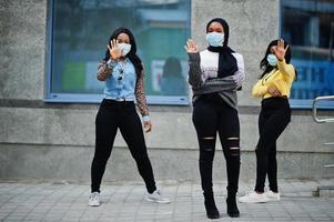 Group of three african american young volunteers wearing face mask outdoors. Coronavirus quarantine and global pandemic. photo