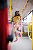 Young stylish african american woman in modern sunglasses riding on a bus. photo