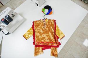 Children's carnival hand made boy costume at seamstress office on workplace. photo
