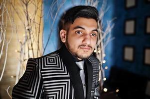 Close up portrait of young indian handsome business man at evening suit and tie on restaurant. photo