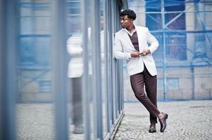 Thoughtful young handsome african american gentleman in formalwear. Black stylish model man in white jacket. photo