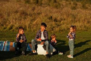 familia pasando tiempo juntos. cuatro niños comen sandía al aire libre. foto