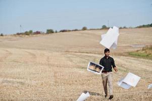 South asian agronomist farmer threw the papers into the sky at wheat field. Agriculture production concept. photo