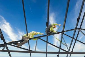 Construction workers wear safety harnesses and safety harnesses working on industrial metal roofs. photo