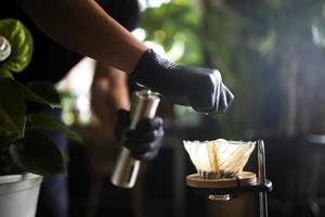 verter a mano el café de la cafetera moka. cafetería en asia. foto