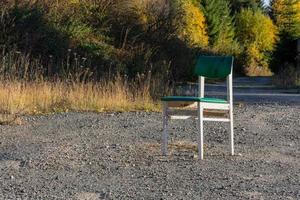 Single white wooden chair outdoors on gravel photo