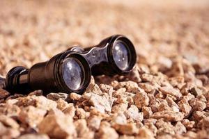 old binoculars on pebbles photo