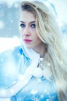 Beautiful young woman in winter snow photo