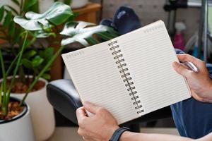man sitting and resting using a pen to write a notebook.Business and education concept. photo