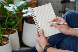 man sitting and resting using a pen to write a notebook.Business and education concept. photo