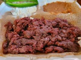 Ethiopian food kitfo raw beef and injera bread photo